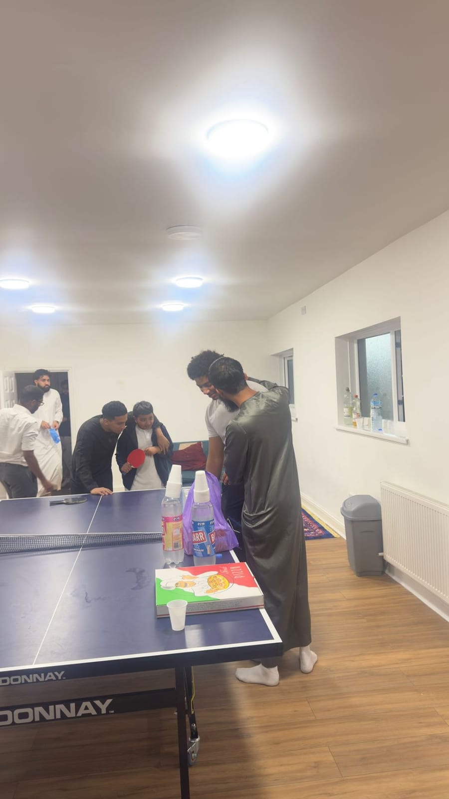 Young people playing table tennis together at a GroundRoots session in the Suhbah Centre, Plaistow